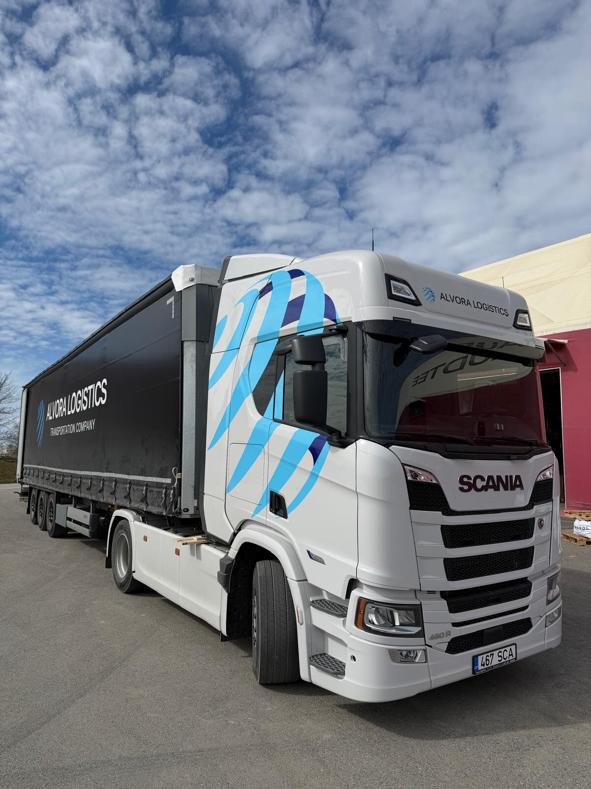 Alvora Logistics white Scania 480R with black curtain-side tautliner trailer at a loading yard